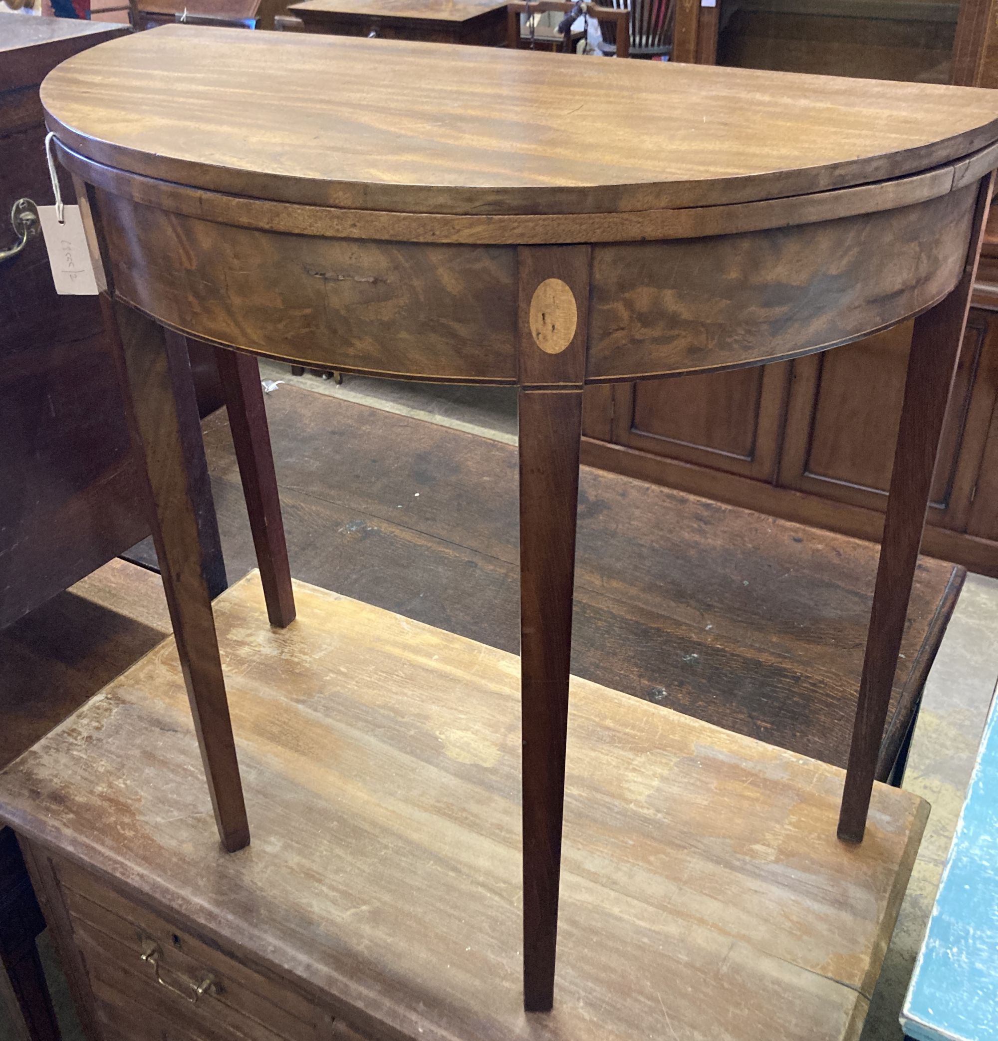 A George III inlaid mahogany demi lune folding tea table, width 78cm, depth 38cm, height 74cm